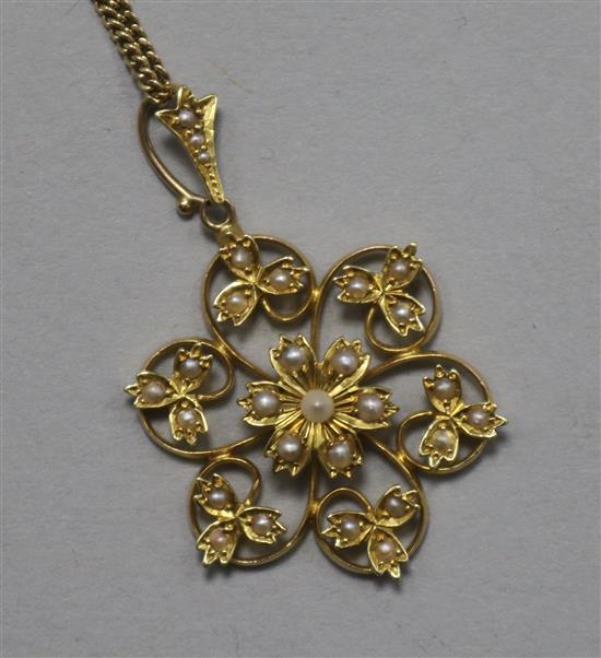 An Edwardian 18ct and 15ct gold, seed pearl flower head pendant, on an 18ct gold fine link chain, pendant 37mm.